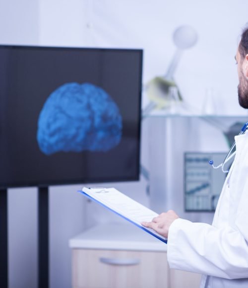 Doctor in his cabinet looking at a braind and trying to put a diagnosis. Doctor giving his expertise.